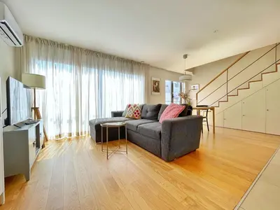 a living room with a couch and a table at Sunny rooftop duplex with elevator near iconic bridge in Vila Nova de Gaia