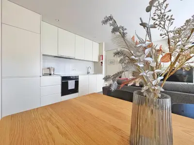 a kitchen with a table and a vase with flowers at Sunny rooftop duplex with elevator near iconic bridge in Vila Nova de Gaia