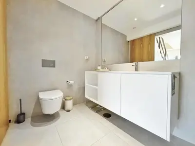a bathroom with a white toilet and a sink at Sunny rooftop duplex with elevator near iconic bridge in Vila Nova de Gaia
