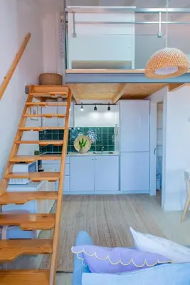 a loft bed in a small room with a ladder at VIVA Fontainhas Houses in Porto