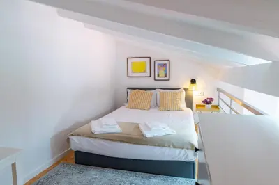 a bedroom with a bed in a white room at VIVA Fontainhas Houses in Porto