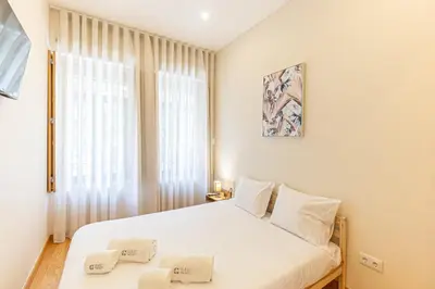 a bedroom with a white bed and a window at GuestReady - Porto stay with homely touches in Porto