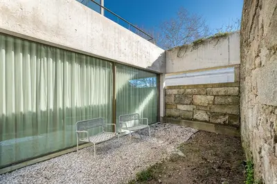 two chairs sitting in a courtyard next to a building at GuestReady - DPV GuestHouse - Apart 6 in Porto