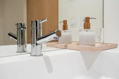 a bathroom counter with three soap dispensers and a sink at GuestReady - DPV GuestHouse - Apart 6 in Porto