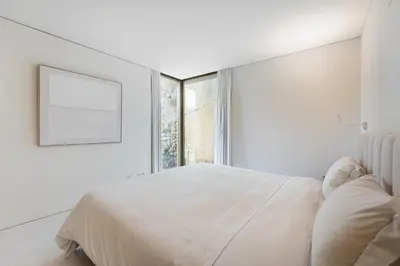 a white bedroom with a large bed and a window at GuestReady - DPV GuestHouse - Apart 6 in Porto