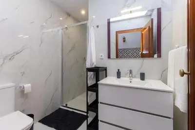 a white bathroom with a sink and a shower at Home Sweet Home in Porto