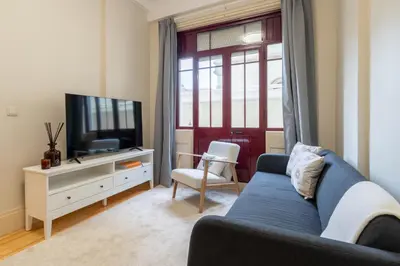 a living room with a blue couch and a tv at Modern & Cozy Flat with Workspace by HostWise in Porto
