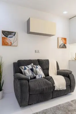 a brown couch sitting in a living room at Sleek Apartment with Balcony by HostWise in Porto