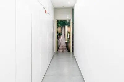 a corridor in a building with white walls and an open door at Sleek Apartment with Balcony by HostWise in Porto