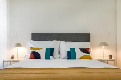 a bedroom with a large bed with white sheets and pillows at Antas Park with pool and gym - to work & leisure in Porto