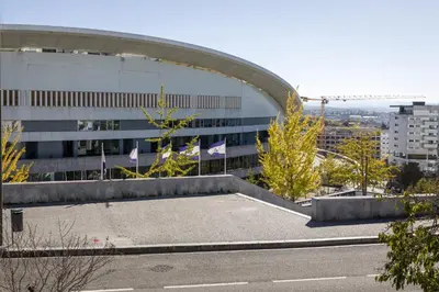a large building with flags in front of it at Antas Park with pool and gym - to work & leisure in Porto