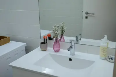 a white bathroom with a sink and a mirror at VIVA República Serviced Apartment in Porto