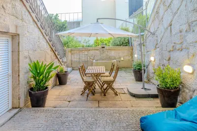 a table and chairs with an umbrella on a patio at VIVA República Serviced Apartment in Porto
