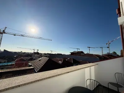 a view of a city from a balcony with cranes at Pinheiro Houses's- Luxury Apartment's by Oporto Soul in Porto