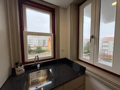 a kitchen with a sink and two windows at Pinheiro Houses's- Luxury Apartment's by Oporto Soul in Porto
