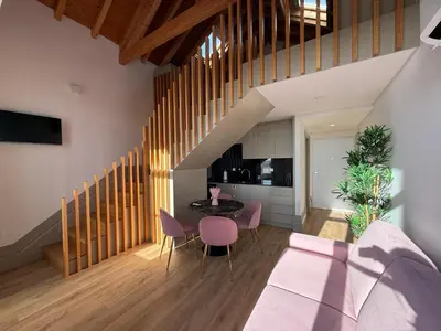 a living room with a table and pink chairs at Pinheiro Houses's- Luxury Apartment's by Oporto Soul in Porto