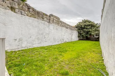 a stone wall with a green field of grass at OPORTO GUEST São Brás 66 in Porto
