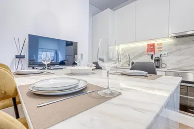 a kitchen with a table with plates and wine glasses at OPORTO GUEST São Brás 66 in Porto
