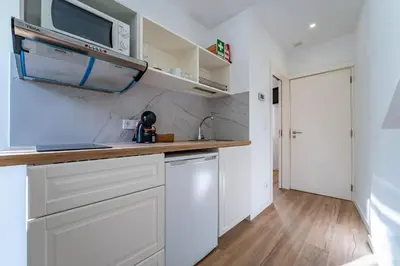 a kitchen with white cabinets and a microwave at Oporto Nura House Duplex Downtown in Porto