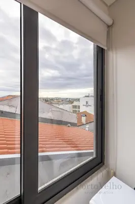 a window with a view of a roof at Gloria in Porto - Porto Velho Apt in Porto