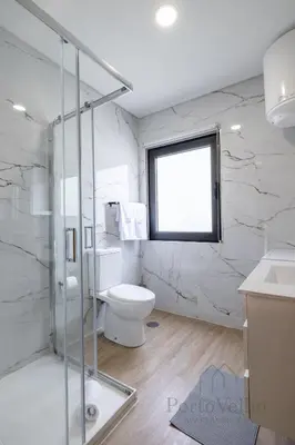 a white bathroom with a toilet and a window at Gloria in Porto - Porto Velho Apt in Porto
