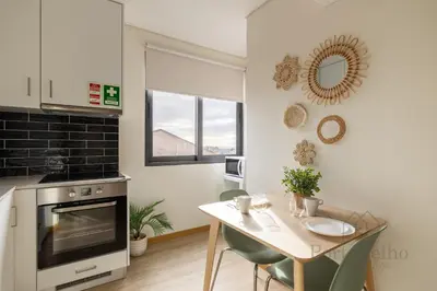 a kitchen with a table and a dining room at Gloria in Porto - Porto Velho Apt in Porto