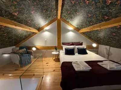 a attic room with a bed and a couch at Catarina de Alexandria by Porto Stories in Porto