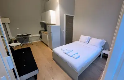 a small bedroom with a white bed with two pillows at Riko Guest House 2 in Porto