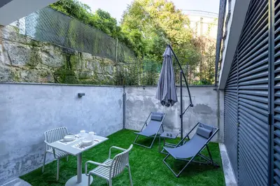 a white table with a vase and plates on it at Nicos Garden Apartment - Porto Velho Apt in Porto