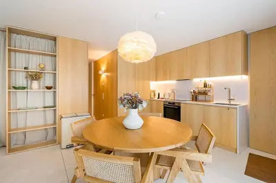 a kitchen and dining room with a wooden table and chairs at DPV Residences - Studio CA/C1 in Porto