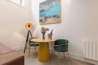 a table and chairs in a living room with a painting at Design loft, Downtown Porto in Porto