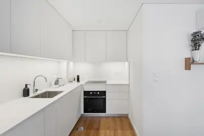 a white bathroom with a sink and a mirror at Brand new luxurious 2-Bedroom Duplex in Porto