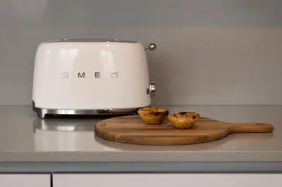 two muffins on a cutting board next to a toaster at Ribeira Apartments Flores in Porto