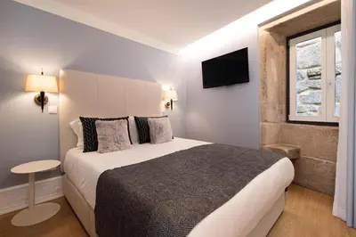 a bedroom with a large bed and a window at Ribeira Apartments Flores in Porto