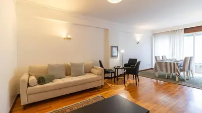 a living room with a couch and a dining room at Charmy Rodrigues Lobo Apartments in Porto