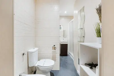 a white bathroom with a toilet and a sink at GuestReady - Relaxing Place with Terrace in Porto