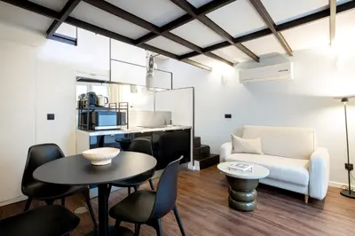 a bedroom with a large white bed and two windows at Fine Arts Ateliers by Olala Homes in Porto