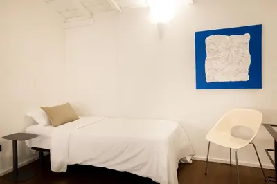 a bedroom with a large bed with a magazine on it at Fine Arts Ateliers by Olala Homes in Porto