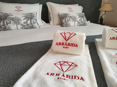 a hotel room with two beds with towels on them at Arrábida Ruby Apartment in Vila Nova de Gaia