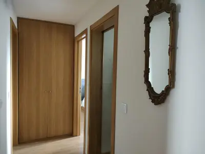 a mirror hanging on a wall next to a closet at Arrábida Ruby Apartment in Vila Nova de Gaia
