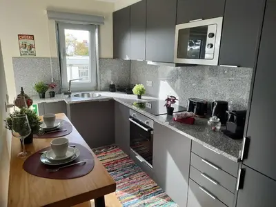 a kitchen with a counter and a table with dishes on it at Arrábida Ruby Apartment in Vila Nova de Gaia