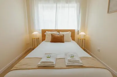 a bedroom with a large bed with two towels on it at Santa Catarina Comfort by Vacationy in Porto