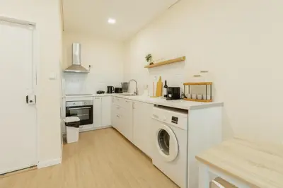 a white kitchen with a washer and dryer at Santa Catarina Comfort by Vacationy in Porto