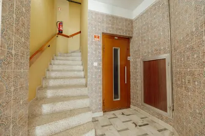 a staircase in a building with a brown door at Santa Catarina Comfort by Vacationy in Porto