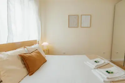 a bedroom with a white bed with two towels on it at Santa Catarina Comfort by Vacationy in Porto