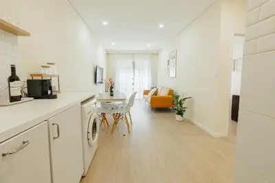 a white kitchen with a table and a dining room at Santa Catarina Comfort by Vacationy in Porto