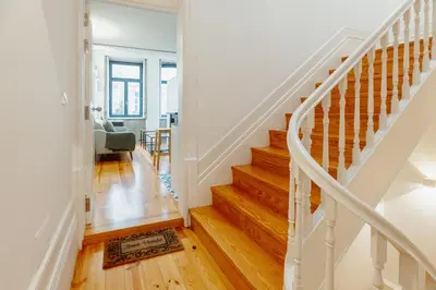a white staircase in a home with wooden floors at Bonfim 362 by Vacationy in Porto
