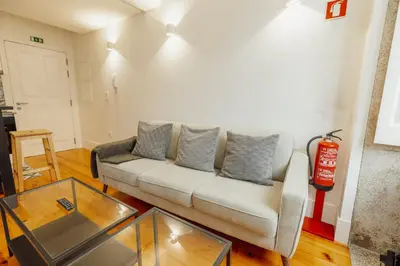 a living room with a couch and a glass table at Bonfim 362 by Vacationy in Porto