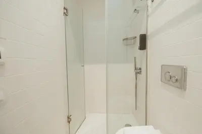 a white bathroom with a shower and a toilet at Elegant Marques Duplex by Vacationy in Porto