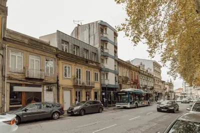 a bus driving down a city street with cars at Elegant Marques Duplex by Vacationy in Porto